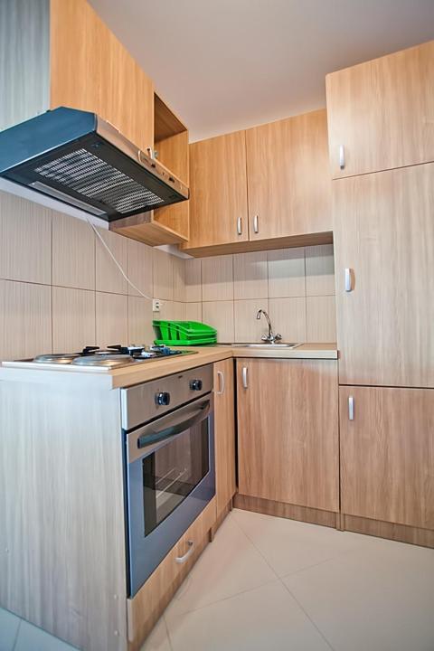 a kitchen with wooden cabinets and a blue stove top oven at Apartments with a parking space Komiza, Vis - 12325 in Komiža