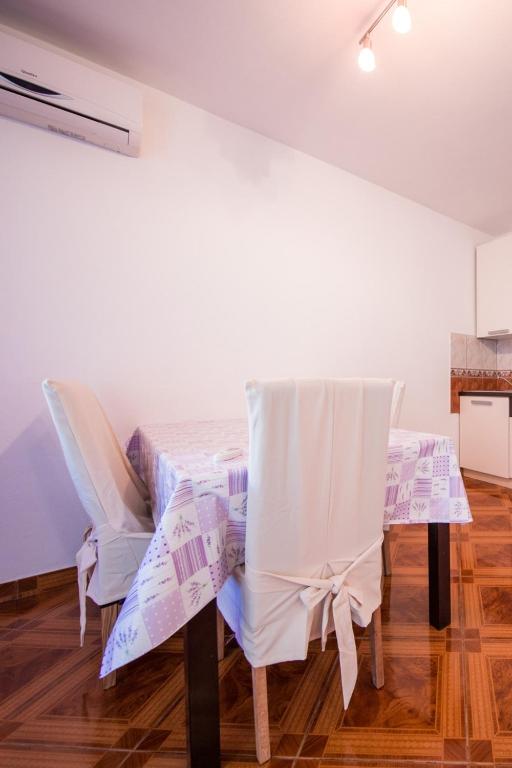 a dining room with a table and chairs at Apartments with a parking space Komiza, Vis - 12325 in Komiža