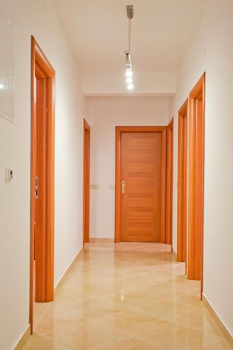 an empty hallway with wooden doors in a building at Apartments with a parking space Komiza, Vis - 12325 in Komiža