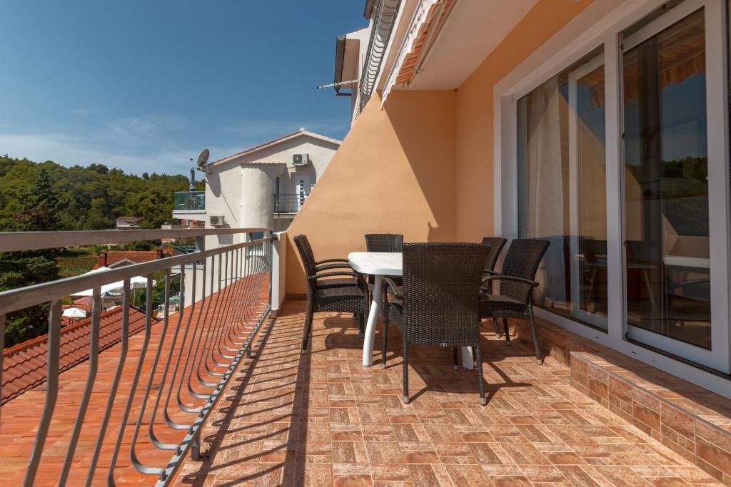 a patio with a table and chairs on a balcony at Apartment Basina 11923a in Vrbanj