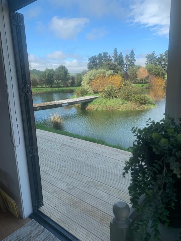 a door to a porch with a view of a river at Bellevue Haven in Masterton
