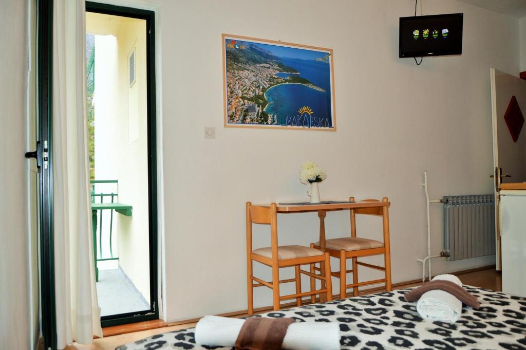 a bedroom with a bed and a table and a chair at Apartments with a parking space Drvenik Donja vala, Makarska - 12297 in Drvenik