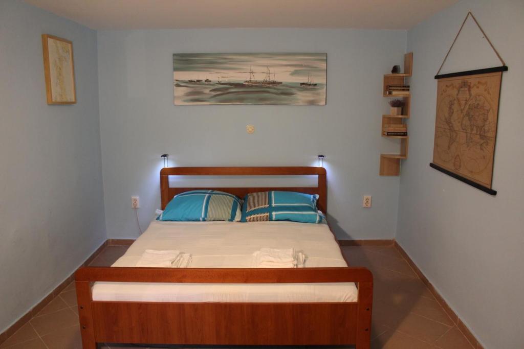 ein Schlafzimmer mit einem Holzbett mit zwei blauen Kissen in der Unterkunft Apartments with WiFi Opatija - 12426 in Opatija