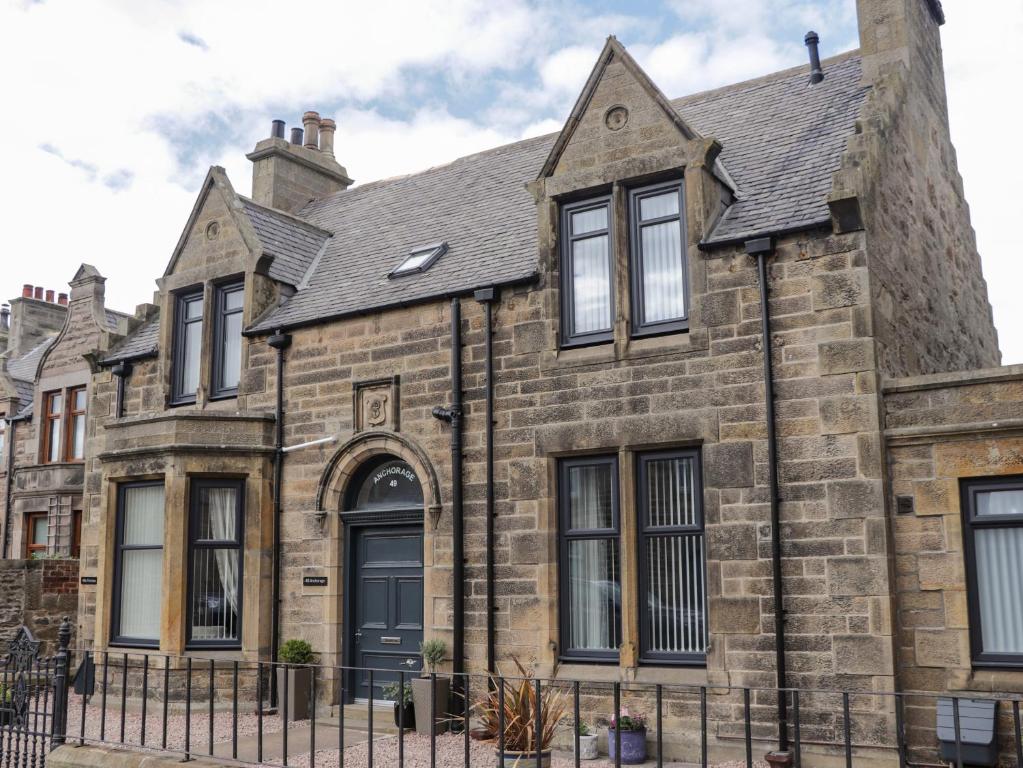 an old stone house with a black fence at Firthview in Buckie