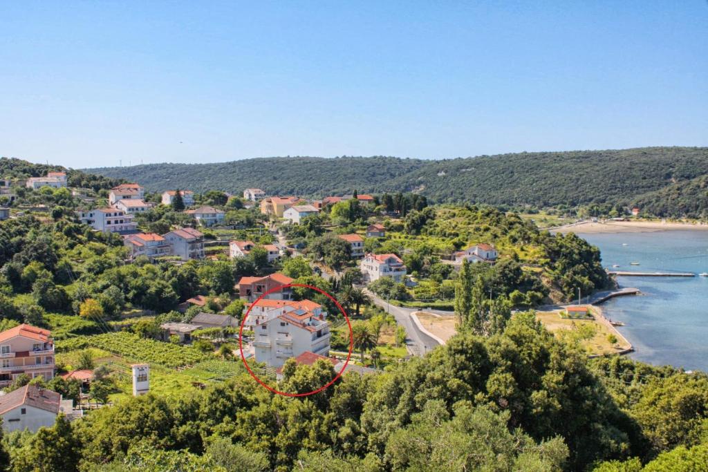 an aerial view of a house on a hill next to a beach at Apartments and rooms by the sea Kampor, Rab - 12473 in Rab