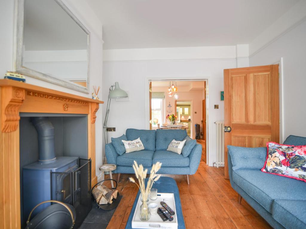 a living room with two blue couches and a fireplace at 55 Queen Street in Seaton