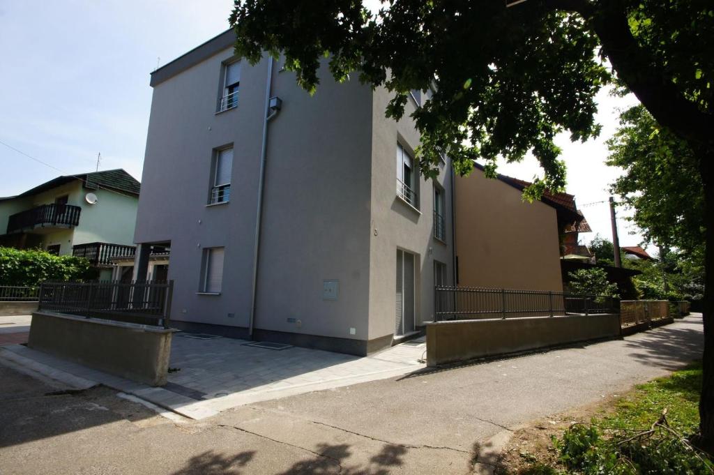 een wit gebouw met een hek ervoor bij Apartments with a parking space Zagreb - 12573 in Zagreb