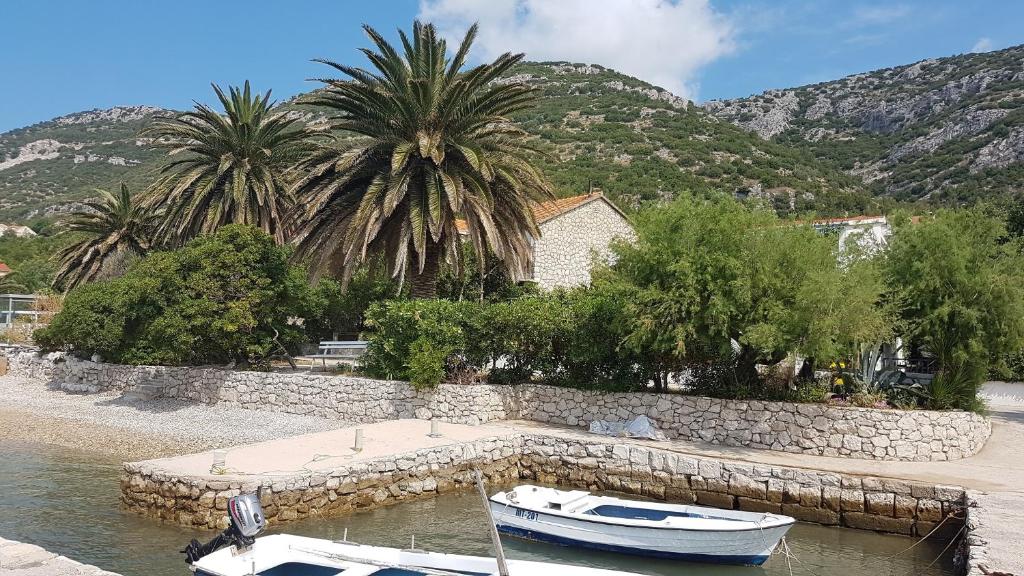 two boats are docked at a dock in the water at Apartments by the sea Viganj, Peljesac - 12564 in Kučište