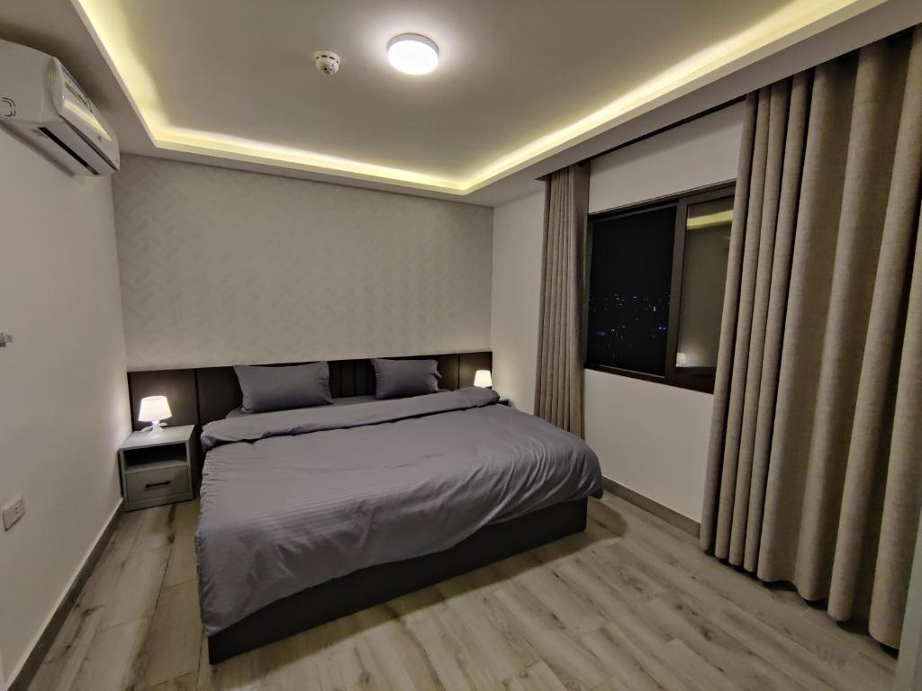 Un dormitorio con una cama grande y una ventana en 44m luxury room near downtown and all services en Amán