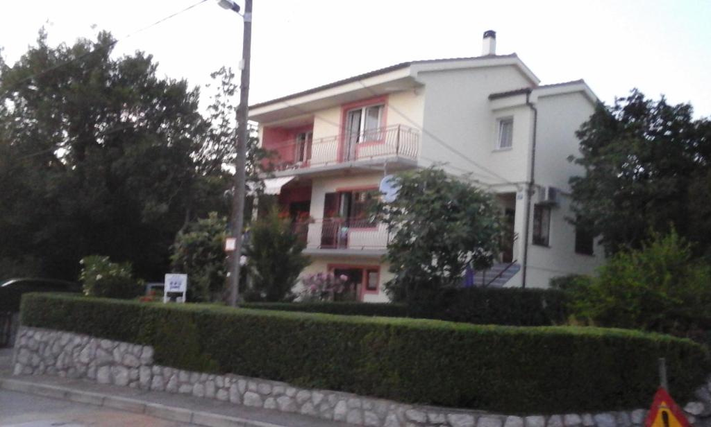 une maison blanche avec une clôture devant elle dans l'établissement Apartments with a parking space Smrika, Kraljevica - 12670, à Šmrika
