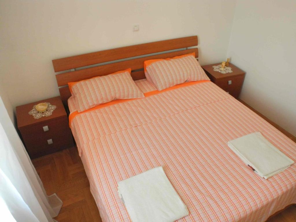 a bedroom with a bed with orange sheets and orange pillows at Apartments by the sea Jezera, Murter - 12728 in Jezera