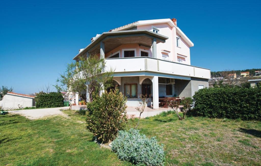 a large white house on a hill with a yard at Apartment Vlasici 12766a in Povljana