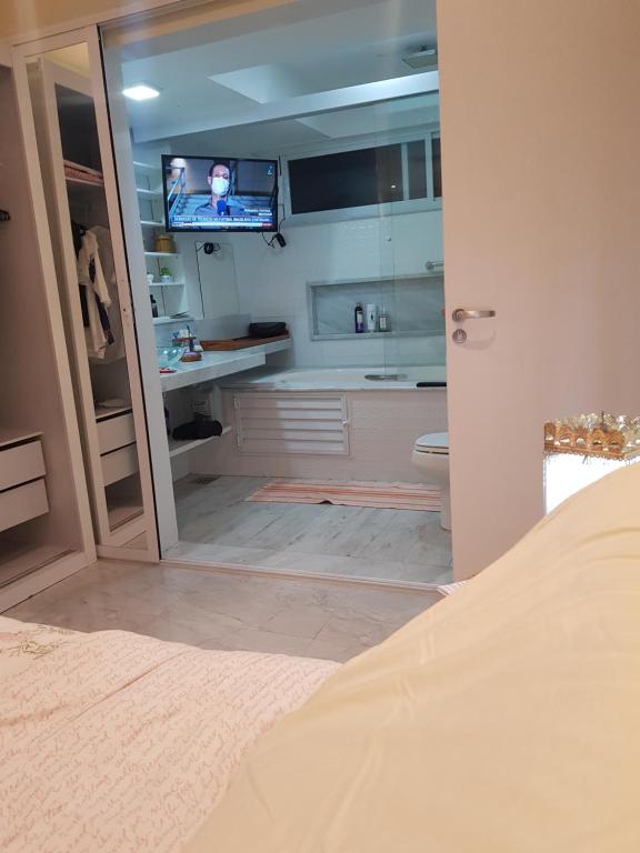 a bathroom with a sink and a toilet and a television at Ipanema RJ 2 quartos in Rio de Janeiro