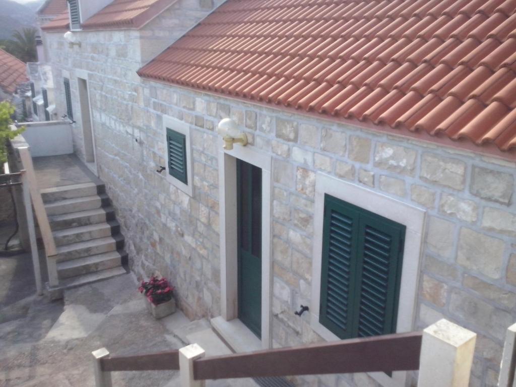 a stone house with a green door and stairs at Apartment Sumartin 11658b in Sumartin
