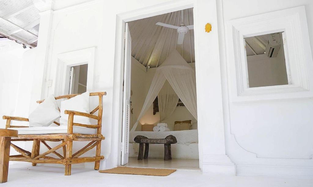 a white room with a chair and a mirror at Sal Secret Spot in Uluwatu