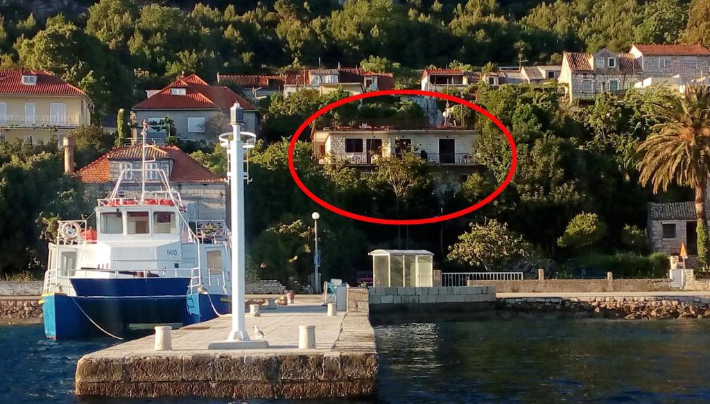 a house in the water next to a boat at Apartments by the sea Kuciste, Peljesac - 12832 in Kučište