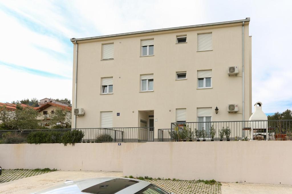 um edifício com um carro estacionado em frente em Apartments with a parking space Podstrana, Split - 12837 em Podstrana