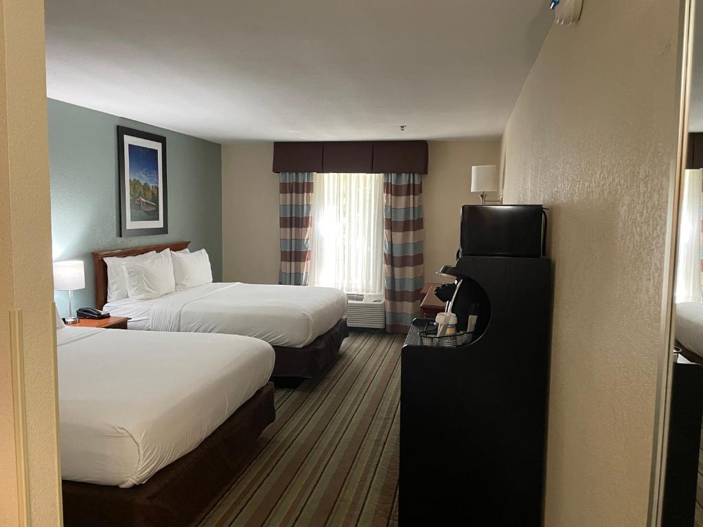 ein Hotelzimmer mit 2 Betten und einem TV in der Unterkunft White Pine Lodge in Salamanca