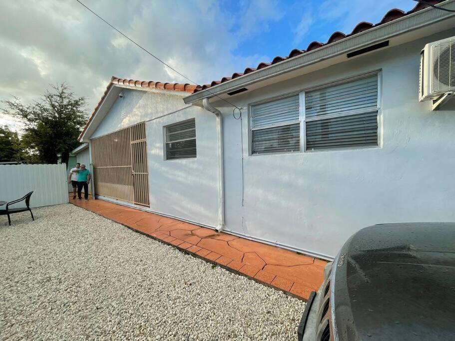 a person standing in front of a white house at Lovely 1-Bedroom Apartment in Miami