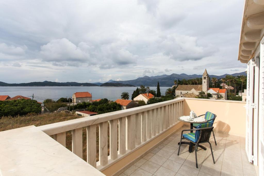a balcony with a table and chairs and a view of the water at Studio Lopud 12910b in Lopud