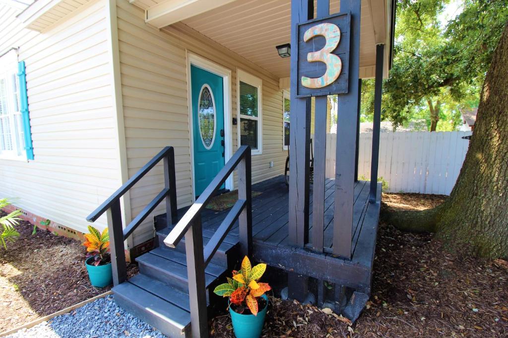 a house with a blue door with a number on it at Beachy Bungalow for Family Fun! Walk to beach! in Pensacola