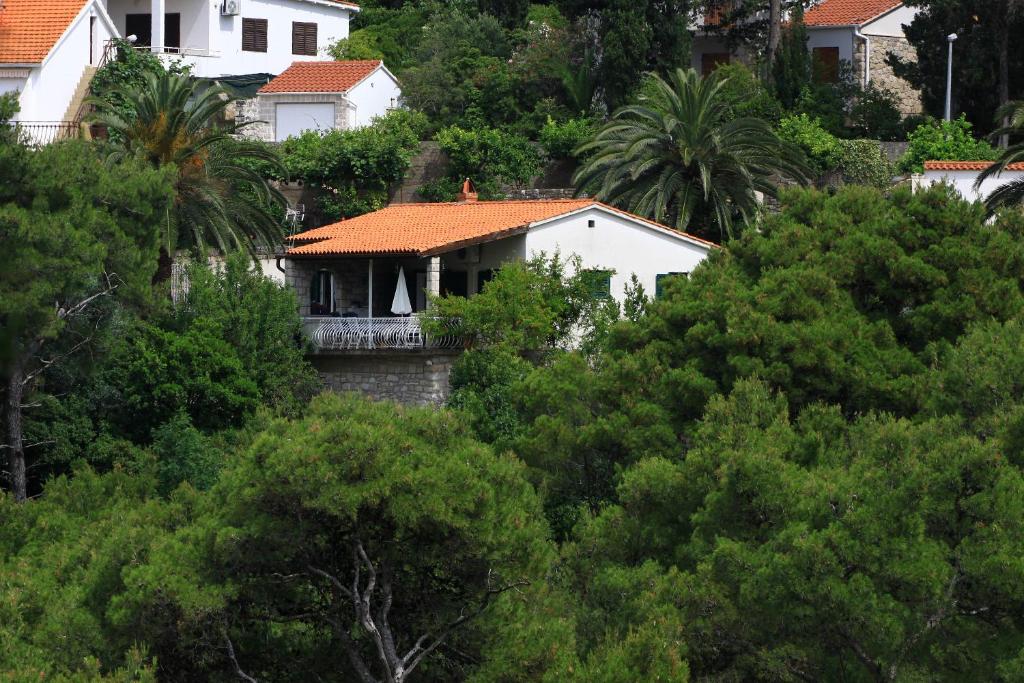 uma casa branca no meio das árvores em Seaside holiday house Postira, Brac - 13001 em Postira