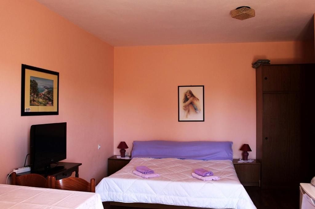 ein Schlafzimmer mit einem Bett und einem TV. in der Unterkunft Apartments by the sea Novalja, Pag - 13033 in Novalja