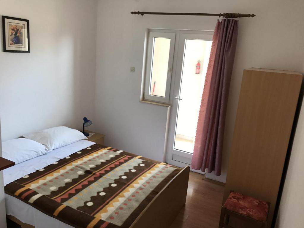 a bedroom with a bed and a window at Double Room Gradac 13179a in Gradac