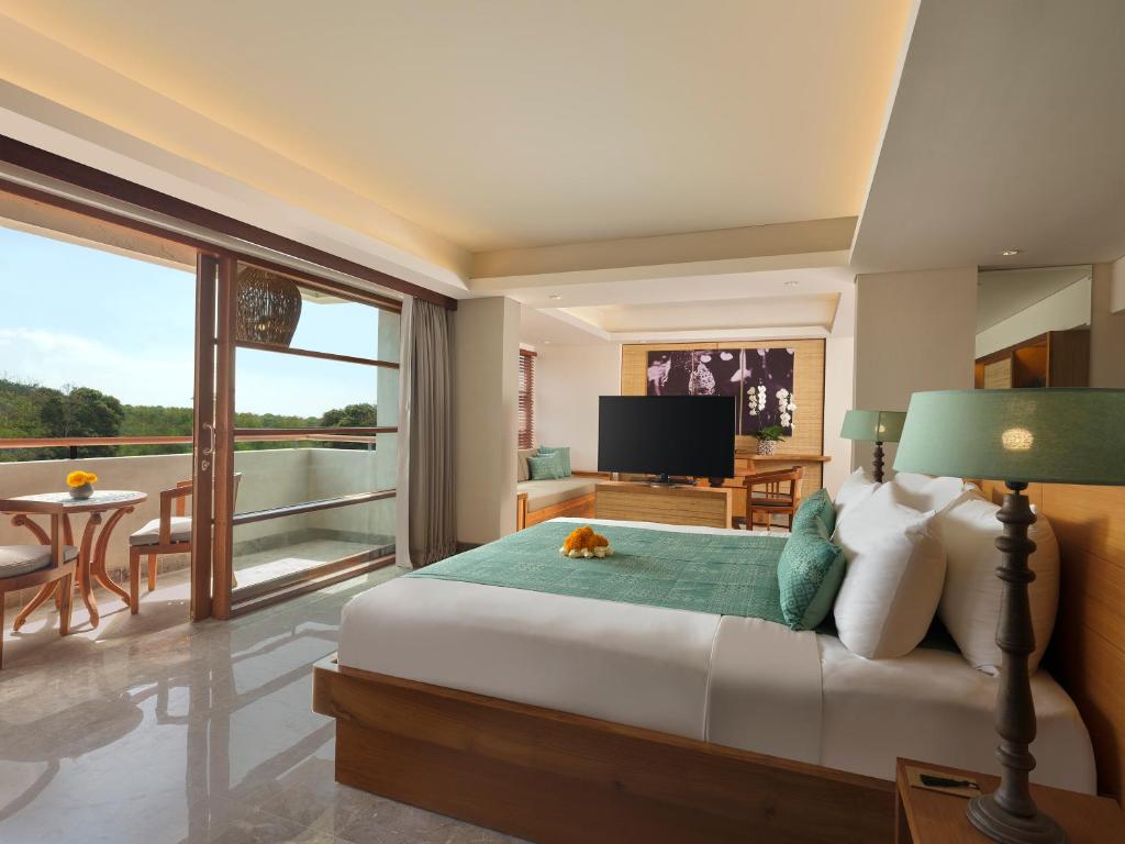 a bedroom with a bed with a cat laying on it at Amnaya Resort Nusa Dua in Nusa Dua