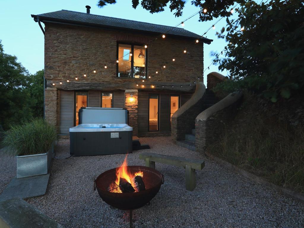 a fire pit in front of a house at The Bothy in Slapton