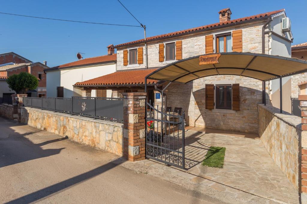 budynek z bramą przed domem w obiekcie Apartments with a parking space Tar, Porec - 13245 w mieście Tar