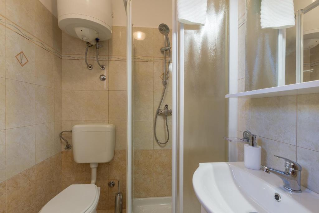 łazienka z toaletą, umywalką i prysznicem w obiekcie Apartments with a parking space Tar, Porec - 13245 w mieście Tar