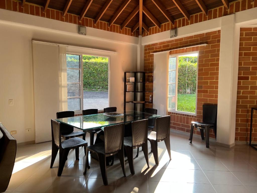 a dining room with a black table and chairs at Casa Campestre Veracruz in Pereira