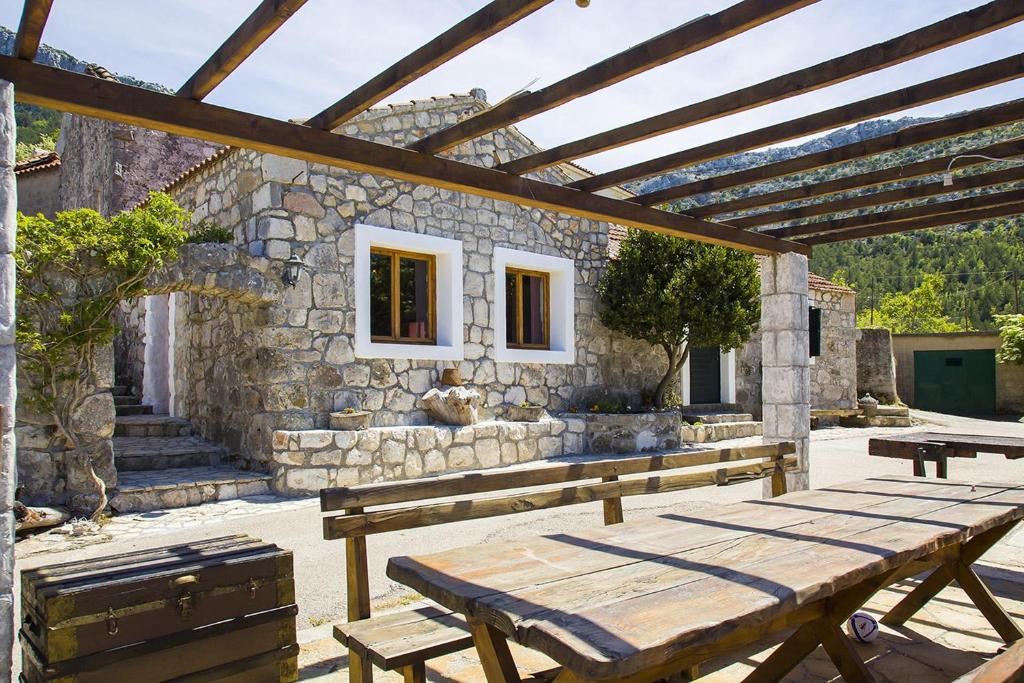 a wooden picnic table in front of a stone building at Secluded house with a parking space Tomislavovac, Peljesac - 13280 in Putniković