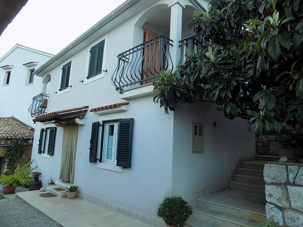 a white house with a staircase and a balcony at Apartments with a parking space Zagore, Opatija - 13277 in Mošćenička Draga