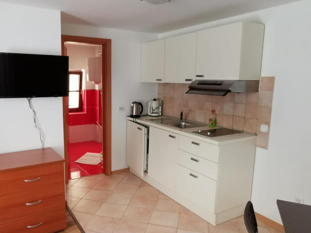 eine Küche mit weißen Schränken und einem Waschbecken in der Unterkunft Apartments by the sea Cres - 13312 in Cres