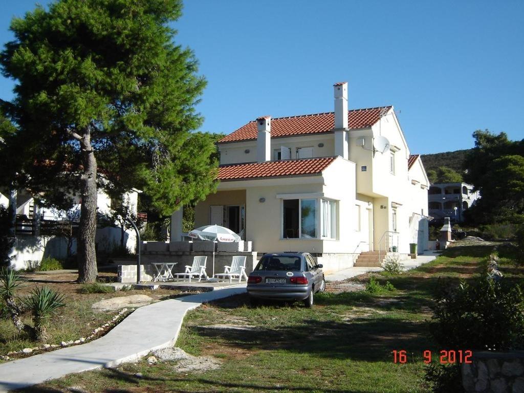 una casa con un coche aparcado delante de ella en Apartments by the sea Brgulje, Molat - 13318 en Molat