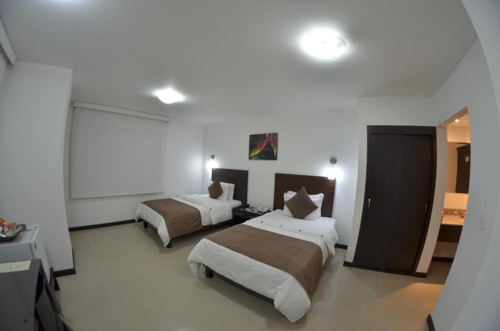 Postel nebo postele na pokoji v ubytování Hotel Pinares Plaza