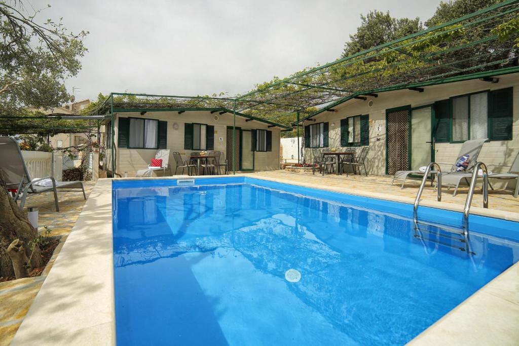 a swimming pool in front of a house at Family friendly apartments with a swimming pool Bol, Brac - 13364 in Bol