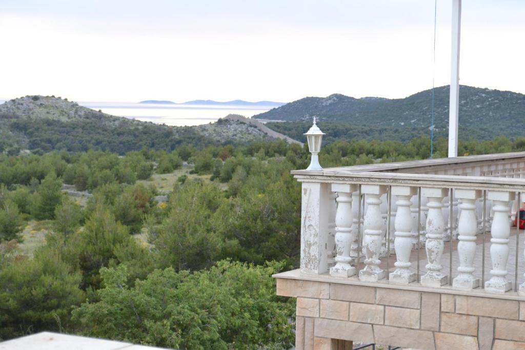 a balcony of a building with mountains in the background at Apartments with a parking space Grebastica, Sibenik - 13365 in Bašelovići