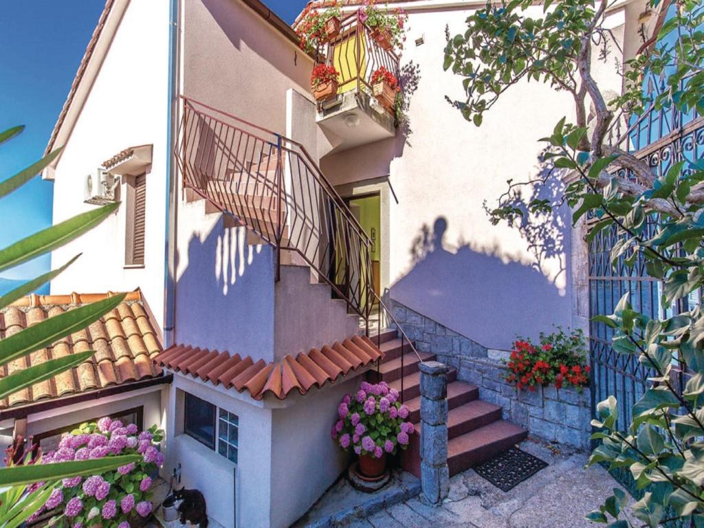 a building with stairs and flowers in front of it at Apartments with a parking space Kastav, Opatija - 13441 in Kastav