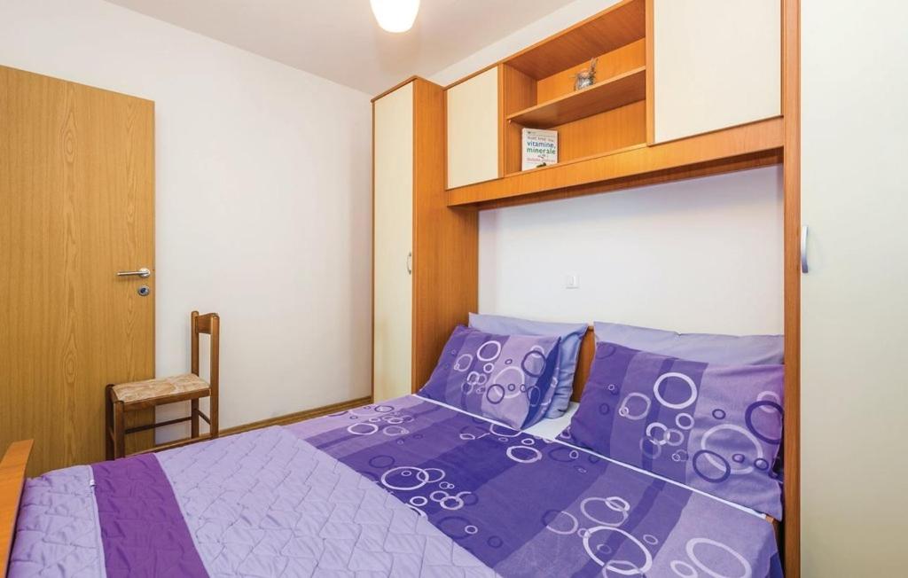 a bedroom with a bed with purple comforter at Apartments with a parking space Kastav, Opatija - 13457 in Kastav
