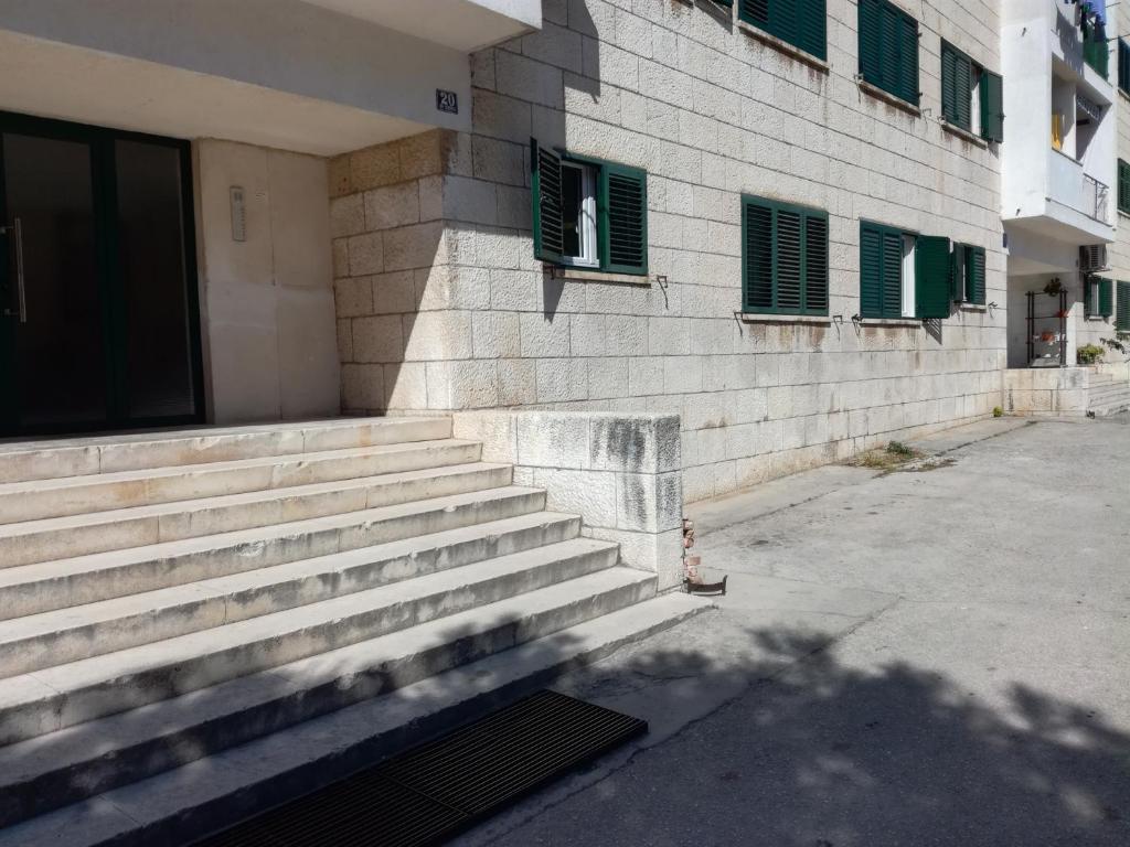 un edificio con escaleras junto a un edificio con persianas verdes en Apartments with WiFi Split - 13459, en Split