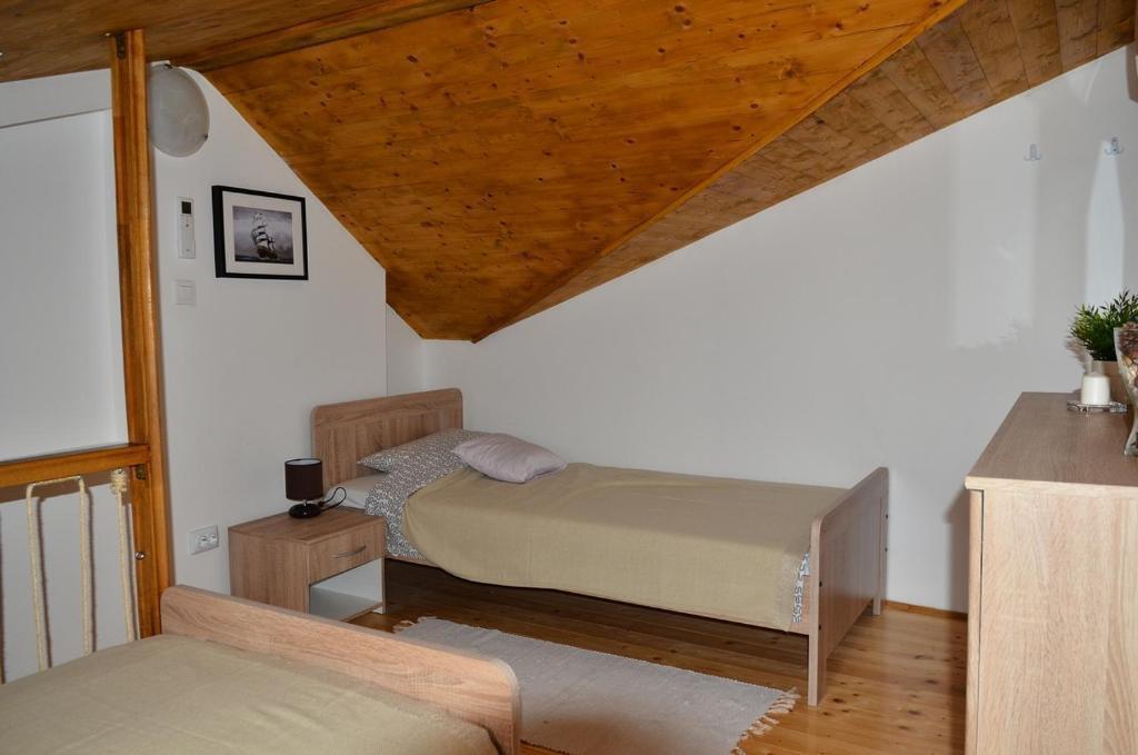a bedroom with two beds and a wooden ceiling at Apartments by the sea Cres - 13510 in Cres