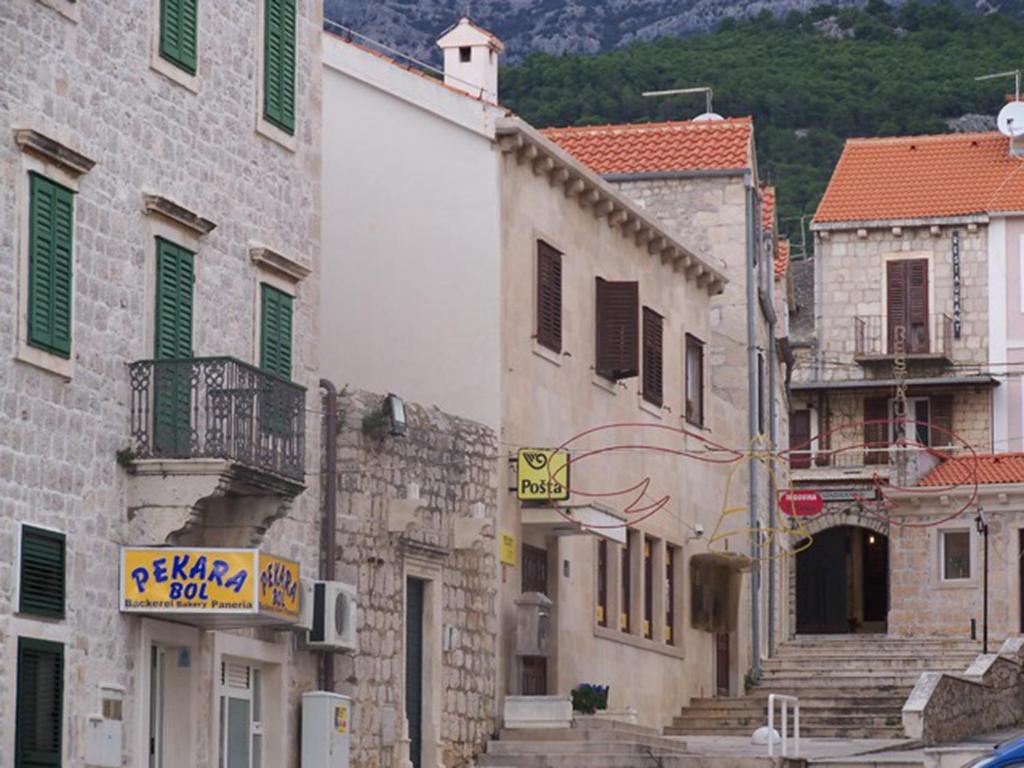 a group of buildings on a city street at Apartments by the sea Bol, Brac - 13539 in Bol