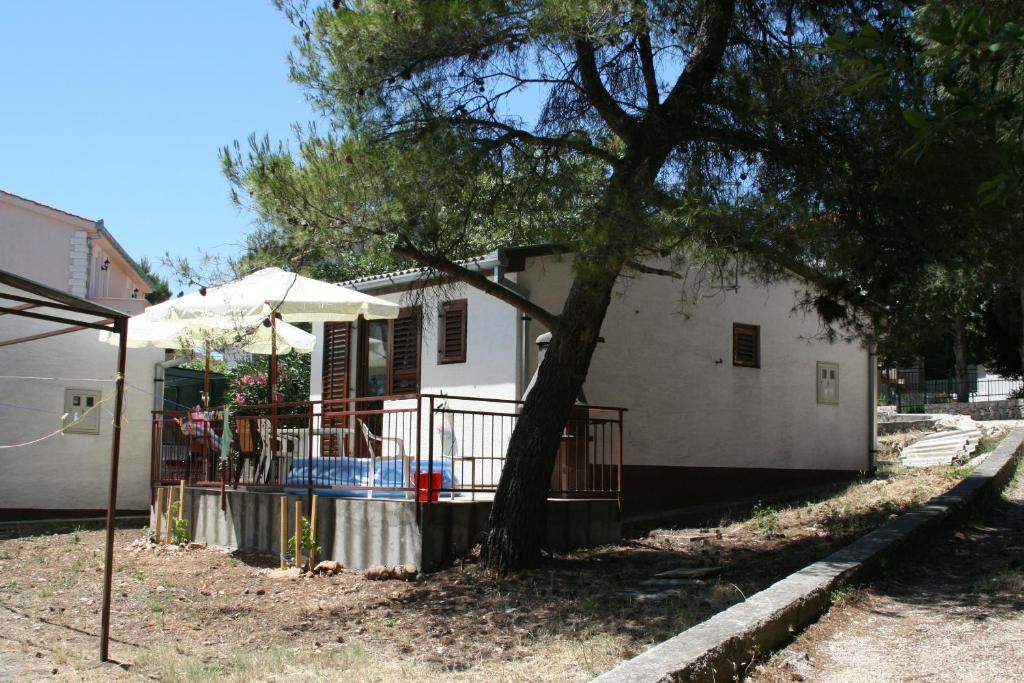 ein weißes Haus mit einem Baum davor in der Unterkunft Seaside holiday house Zatoglav, Rogoznica - 13540 in Rogoznica