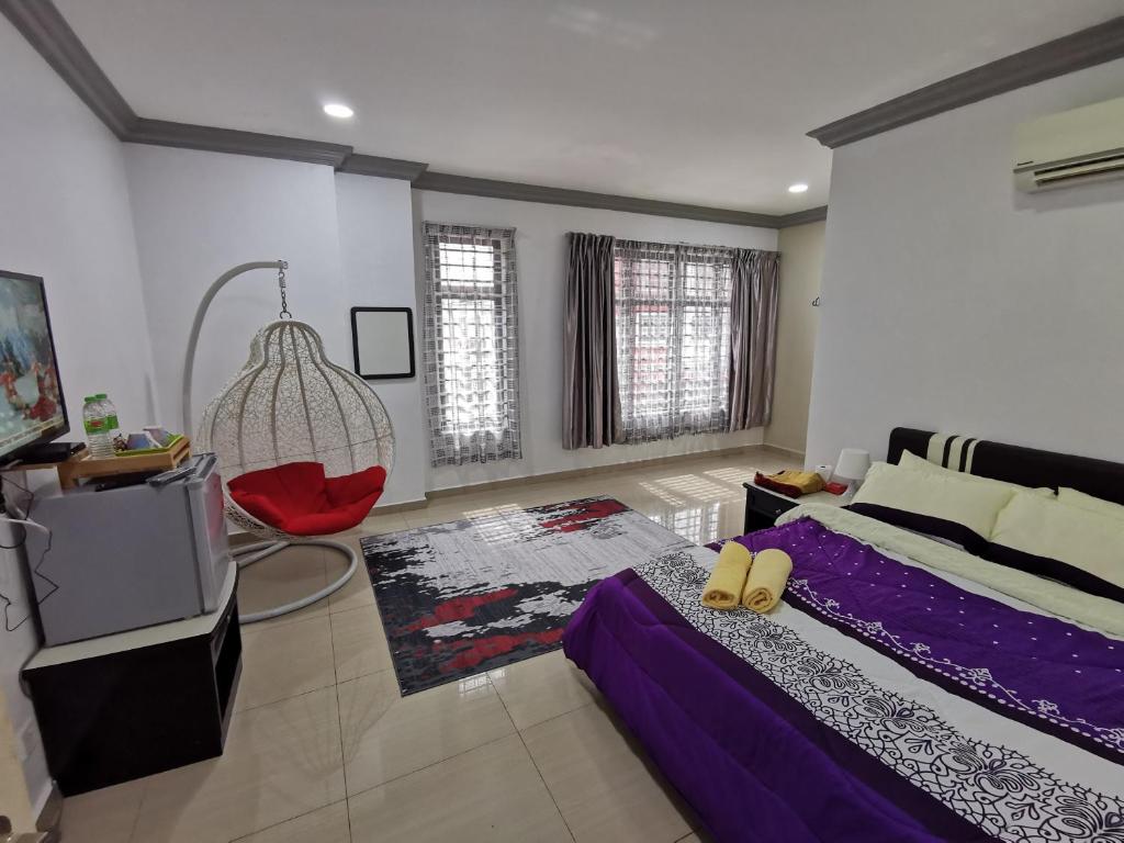 a bedroom with a bed and a red chair at Ourstay Nadi Kota in Bandar  Pusat Jengka