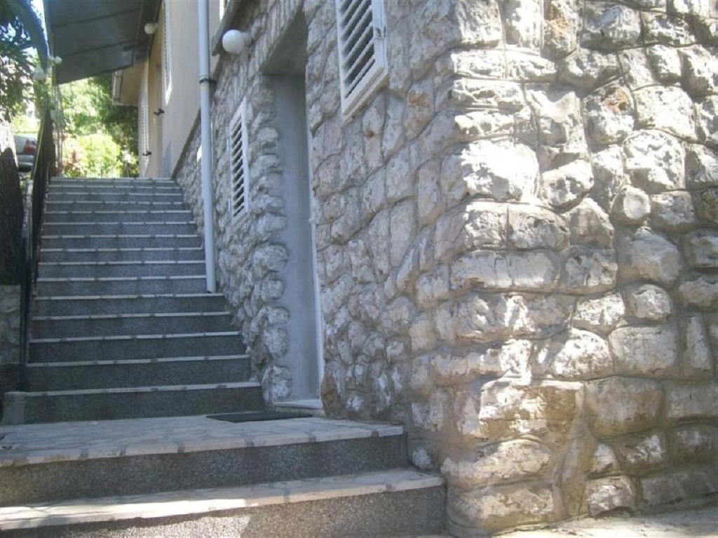 ein Steingebäude mit einer Treppe und einer Steinmauer in der Unterkunft Apartments by the sea Mali Losinj (Losinj) - 13556 in Veli Lošinj