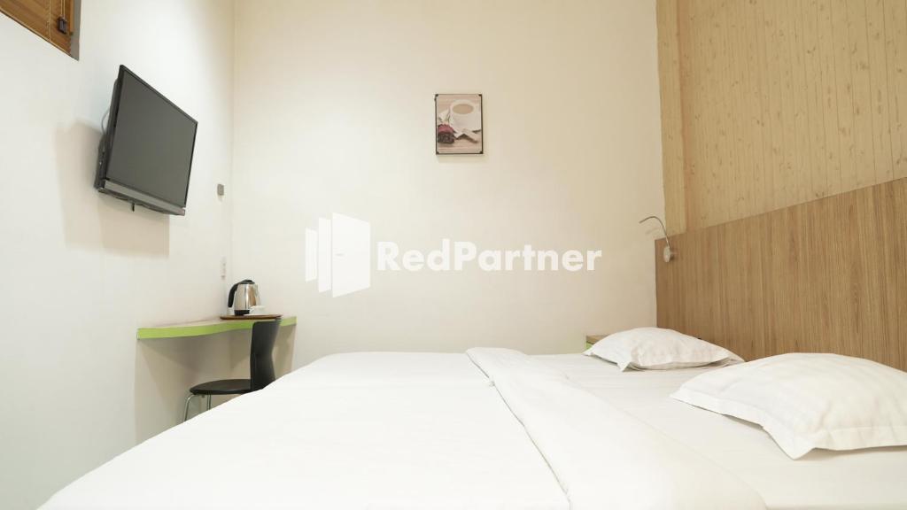 Postel nebo postele na pokoji v ubytování Wisma Sederhana Medan Mitra RedDoorz