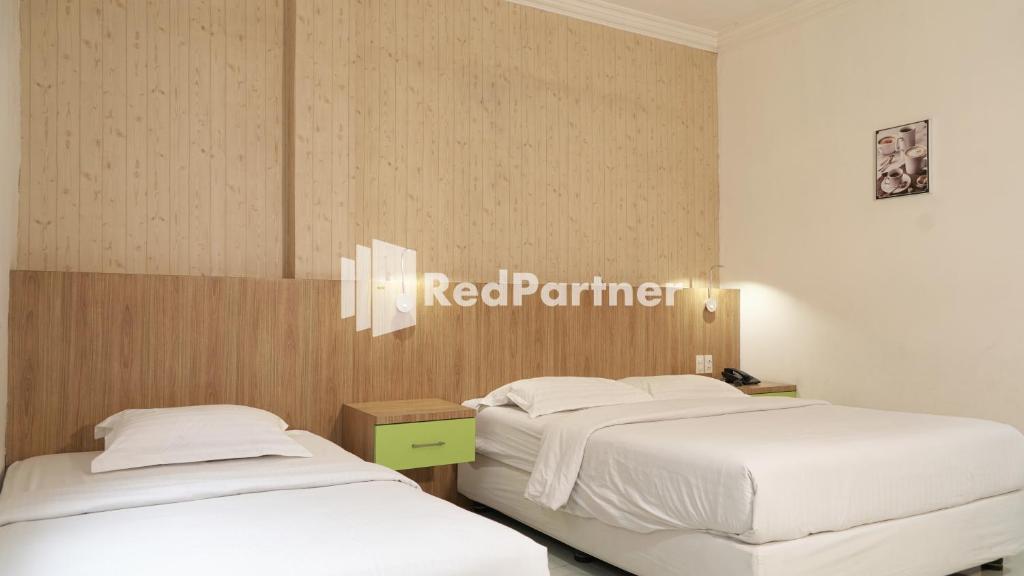 Postel nebo postele na pokoji v ubytování Wisma Sederhana Medan Mitra RedDoorz